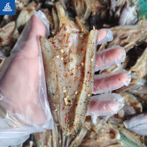 Khô cá lóc 2 nắng được cầm trên tay có đeo bao tay